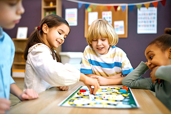 Group of kids playing board game in school